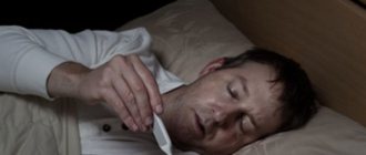 Sick man in bed, looking at thermometer