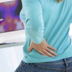 девушка держит руку на пояснице